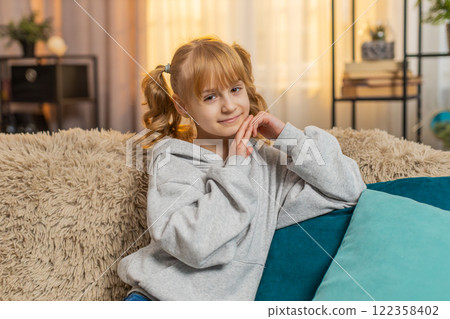 Portrait of young teenager girl looking at camera with a friendly smile and happy expression indoors Portrait of young teenager girl looking at camera with a friendly smile and happy expression indoors 122358402