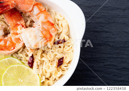 Tom yum soup with shrimps instant noodles and lime photography . Asian food . Top view Tom yum soup with shrimps instant noodles and lime photography . Asian food . Top view 122358438