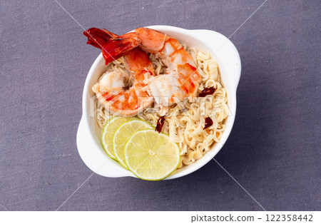 Tom yum soup with shrimps instant noodles and lime photography . Asian food . Top view 122358442