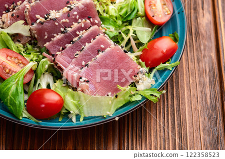 Salad with raw tuna , sesame and cherry tomatoes photography . Top view 122358523