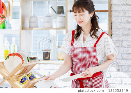 一個圍裙，在廚房裡做飯的女人 122358549