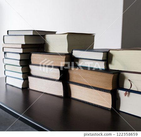 There are a lot of technical books piled up in the room. 122358659