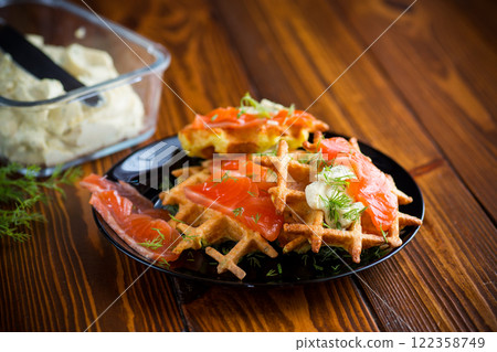 vegetable potato waffles with spread and lightly salted red fish, in a plate on a wooden table 122358749