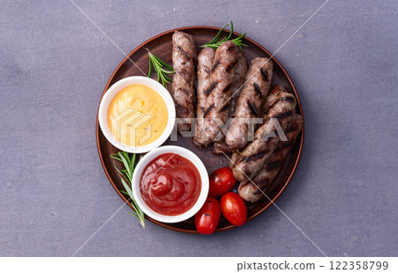 Grilled beef sausages with rosemary sauce and tomatoes photography . Top view Grilled beef sausages with rosemary sauce and tomatoes photography . Top view 122358799