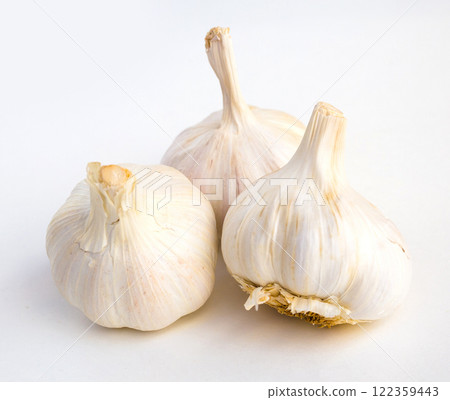 Garlic heads and cloves on white background Garlic heads and cloves on white background 122359443