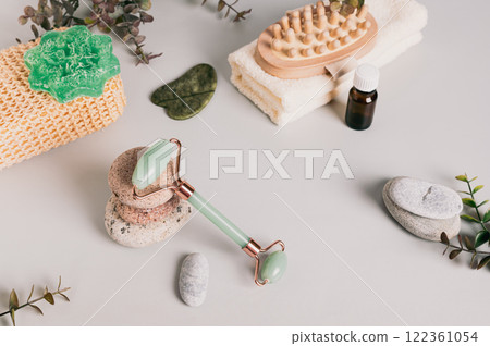 Jade roller for massage, pebbles and spa items on table Jade roller for massage, pebbles and spa items on table 122361054