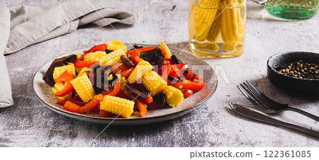 Appetizing salad of canned corn, fried mushrooms and peppers on a plate web banner 122361085