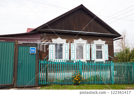 An old wooden house with carved shutters and architraves in the village .  122361417