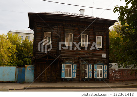 A wooden old two-storey house with carved shutters and architraves in the historical center of the city.  122361418