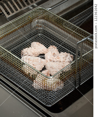 Frying golden chicken wings in deep fryer Frying golden chicken wings in deep fryer 122361642