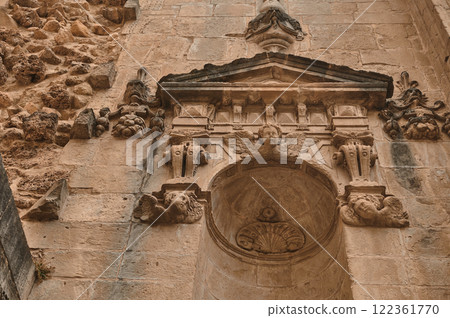 Ornate stone facade with detailed angel sculpture and floral carvings 122361770