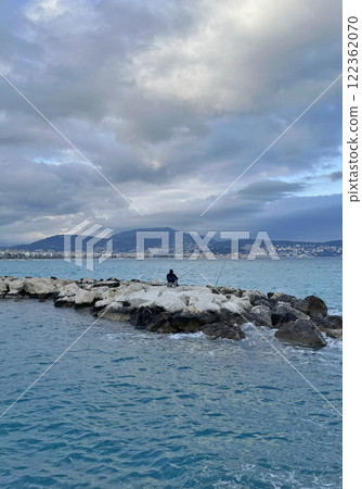 Solitary Fisherman on the Rocky Shoreline in Nice, France Solitary Fisherman on the Rocky Shoreline in Nice, France 122362070