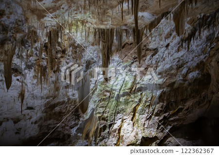 The cave is karst, amazing view of stalactites and stalagnites illuminated by bright light, a beautiful natural attraction in a tourist place. 122362367
