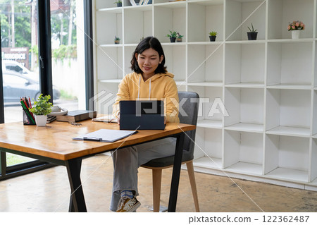 Intelligent young woman having online lessons on laptop, drinking coffee and taking notes, Intelligent young woman having online lessons on laptop, drinking coffee and taking notes, 122362487