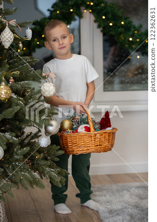 Happy little boy with Christmas tree toys in the Christmas room. Happy little boy with Christmas tree toys in the Christmas room. 122362631