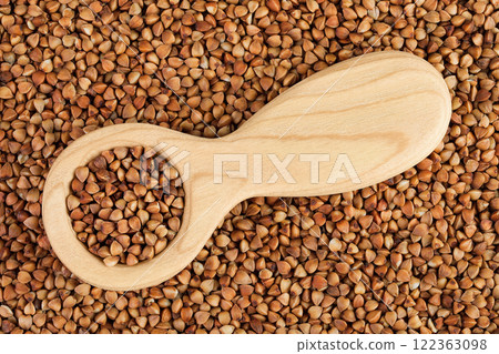 Raw buckwheat in wooden spoon as a background. Top view. Flat lay 122363098