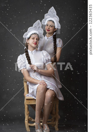 Two Russian Girls in a Snow Maiden costume posing on a gray background. 122363435