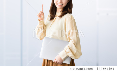 A smiling woman/businesswoman giving directions while holding a computer A smiling woman/businesswoman giving directions while holding a computer 122364164