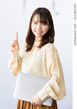 A smiling woman/businesswoman giving directions while holding a computer A smiling woman/businesswoman giving directions while holding a computer 122364165