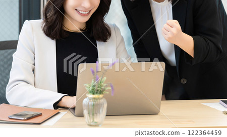 Two women/businesswomen using a computer 122364459