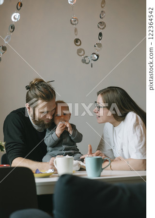A delightful family bonding moment captured in a cozy cafe setting, filled with joy 122364542