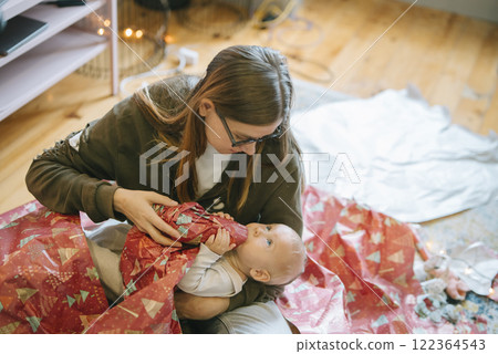 Joyful Holiday Moments Unwrapping Heartwarming Gifts with Your Adorable Baby Together 122364543
