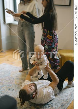 Playful family interaction with a baby in a cozy, joyful living room filled with warmth Playful family interaction with a baby in a cozy, joyful living room filled with warmth 122364609