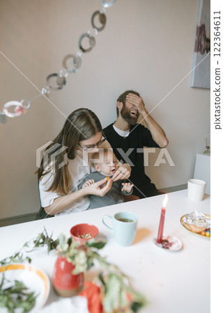 A Joyful Family Moment Feeding the Baby with Lots of Love, Happiness, and Laughter 122364611