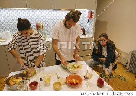 A Group of Friends Enjoying the Experience of Preparing a Meal Together in a Modern Kitchen A Group of Friends Enjoying the Experience of Preparing a Meal Together in a Modern Kitchen 122364728