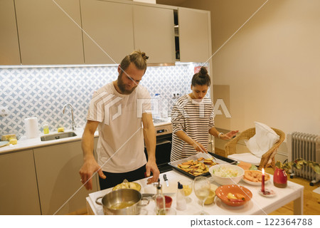 A couple enjoys the simple pleasure of cooking together in a beautifully modern kitchen space 122364788