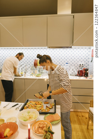 A Couple Cooking Together in their Modern Kitchen, Engaging in Culinary Fun and Enjoyment 122364847