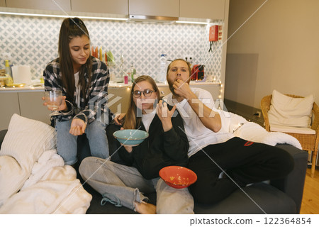 Enjoying a Cozy Evening Together Friends Relishing Delicious Snacks While Hanging Out Enjoying a Cozy Evening Together Friends Relishing Delicious Snacks While Hanging Out 122364854