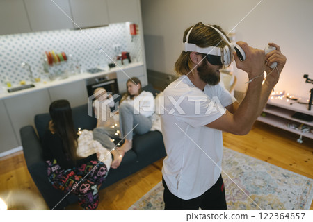 A Family is Enjoying an Engaging Virtual Reality Game Together in the Comfort of Home A Family is Enjoying an Engaging Virtual Reality Game Together in the Comfort of Home 122364857