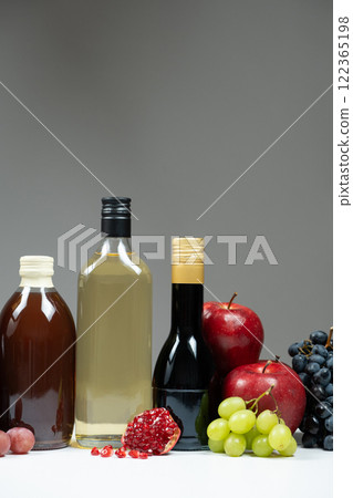 Different types of vinegar. Pomegranate, apple and balsamic vinegars in bottles 122365198