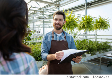 Two professionals talking in the greenhouse discussing plant cultivation Two professionals talking in the greenhouse discussing plant cultivation 122365243