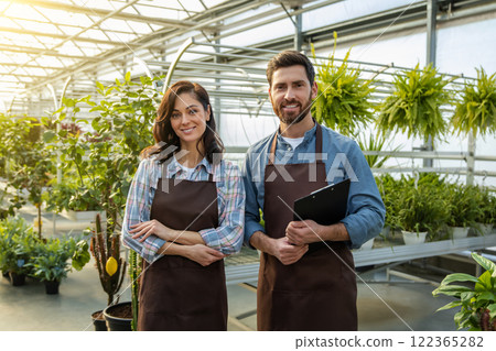 Two workers in a greenhouse looking positive and contented 122365282