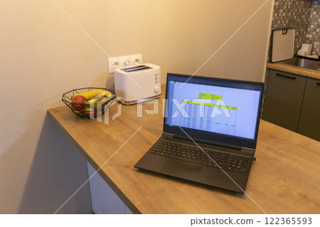 Laptop on the kitchen counter top with an excel sheet on computer screen showing bank loan amortization table. Laptop on the kitchen counter top with an excel sheet on computer screen showing bank loan amortization table. 122365593