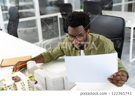 Young male architect looking at the new living area mock up and feeling contented Young male architect looking at the new living area mock up and feeling contented 122365741