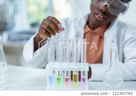 Female scientist holding tubes with liquid conducting experiment in chemistry Female scientist holding tubes with liquid conducting experiment in chemistry 122365765