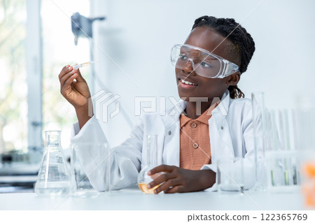 African American scientist in lab using pipette testing bacteria sample in petri dish 122365769