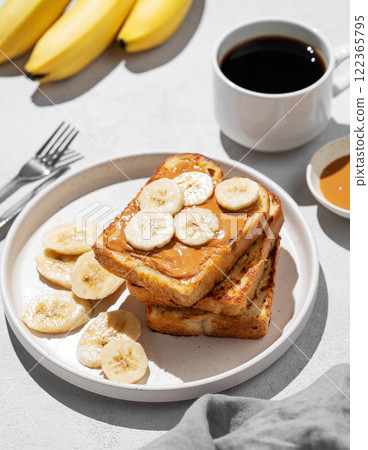 Peanut butter toast  with banana on a plate  on a light background with a cup of espresso coffee 122365795