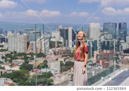 Female tourist or businesswoman standing on a skyscraper rooftop with a panoramic view of Mexico City. Travel or international business in Mexico concept 122365869
