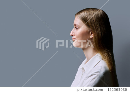 Profile view, confident young woman, copy space gray studio background 122365986