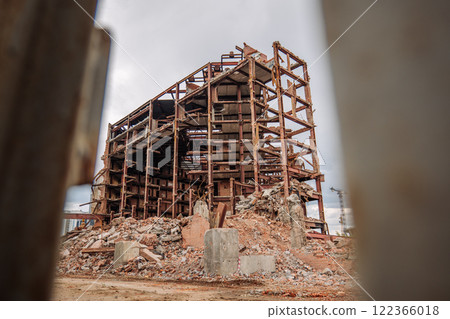 Rusty metal beams and debris pile mark the site of a demolished building in russia, highlighting urban decay and industrial decline 122366018