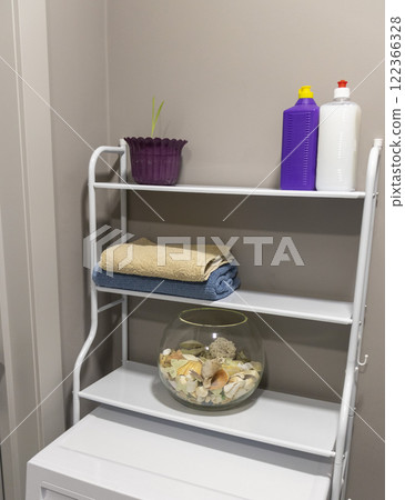 Shelf above the washing machine with household items 122366328
