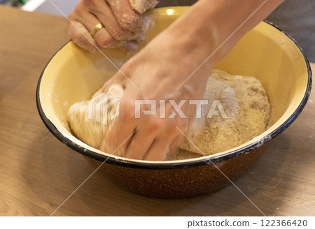 Woman kneads the dough in the bowl Woman kneads the dough in the bowl 122366420