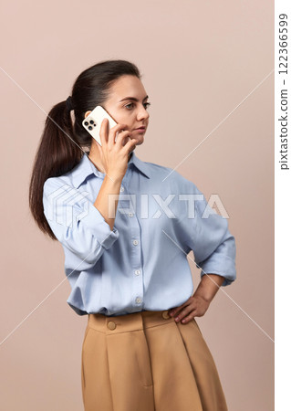 positive Caucasian business woman in blue shirt talking on phone 122366599