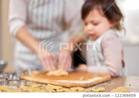 defocused family mother and little child daughter cutting cookies of raw gingerbread dough in kitchen. focus on cookies defocused family mother and little child daughter cutting cookies of raw gingerbread dough in kitchen. focus on cookies 122366609
