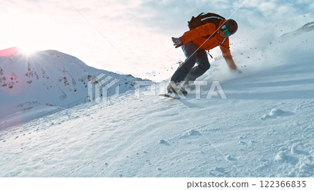 Snowboard rider riding down fresh powder during sunny day , Alpine scenery 122366835