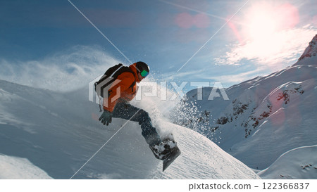 Snowboard rider riding down fresh powder during sunny day , Alpine scenery Snowboard rider riding down fresh powder during sunny day , Alpine scenery 122366837